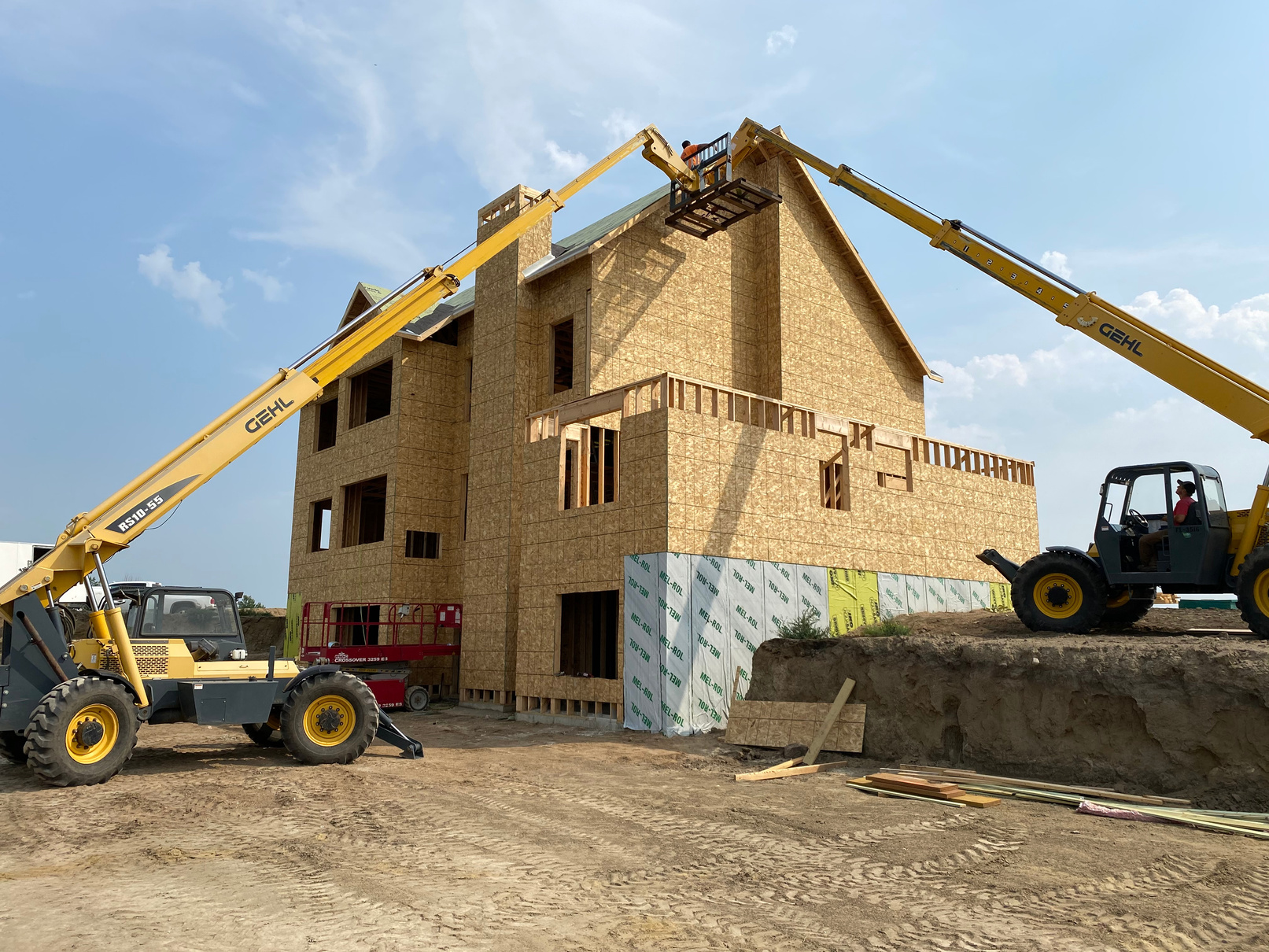 Custom home walls being set with a telehandler